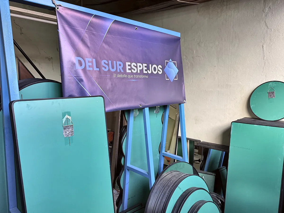 Espejos de Del Sur Espejos terminados, vistos de atrás con el gancho ya colocado, junto al cartel de la marca